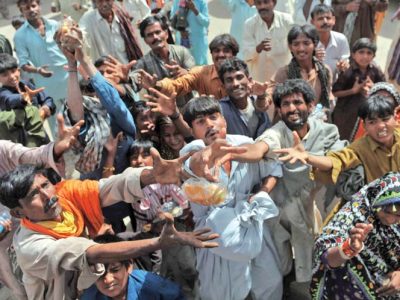 Pakistani drought-affected people stretch their hands to receive food being distributed by a private NGO in Mithi, the main town in the Tharparkar district in southern Sindh province around 300 kilometres east of Karachi on March 12, 2014. Pakistan govermnment and several private NGOs have set up their relief camps in the drought-hit desert region to provide relief assistance to hundreds of thousands affected families where at least 67 children had died due to malnutrition and other diseases in the area since December. AFP PHOTO/Rizwan TABASSUM